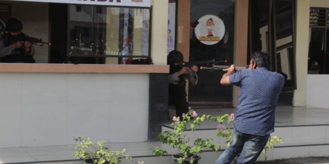 Seorang OTK melakukan penembakan ke arah petugas jaga Polres Lhokseumawe dalam simulasi pengamanan mako yang berlangsung di Mapolres Lhokseumawe, rabu (08/07/2020).